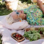 Ältere Frau auf einem Picknicktuch am Sonnnen